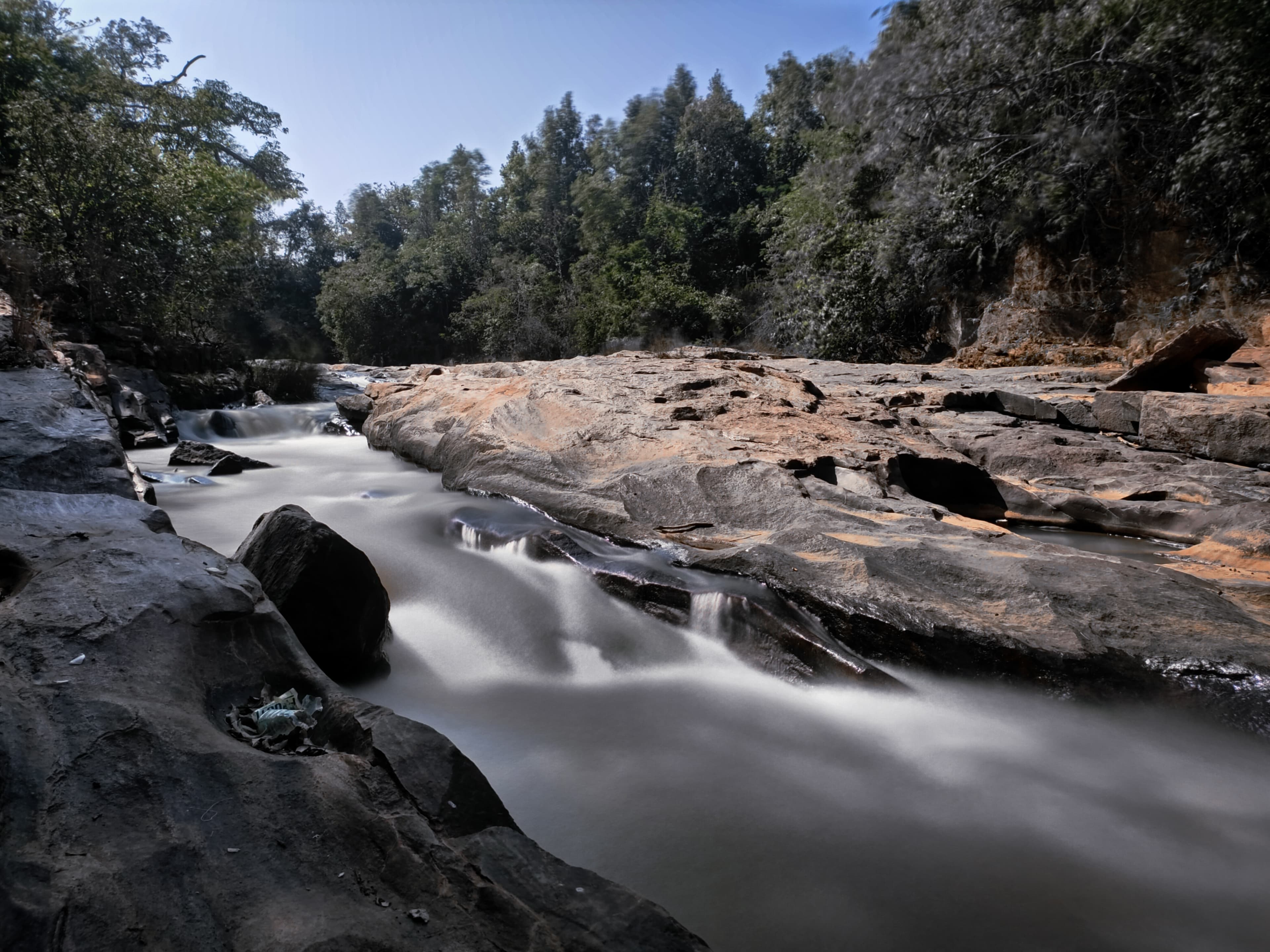 A serene stream flowing through the dense jungles of Similipal