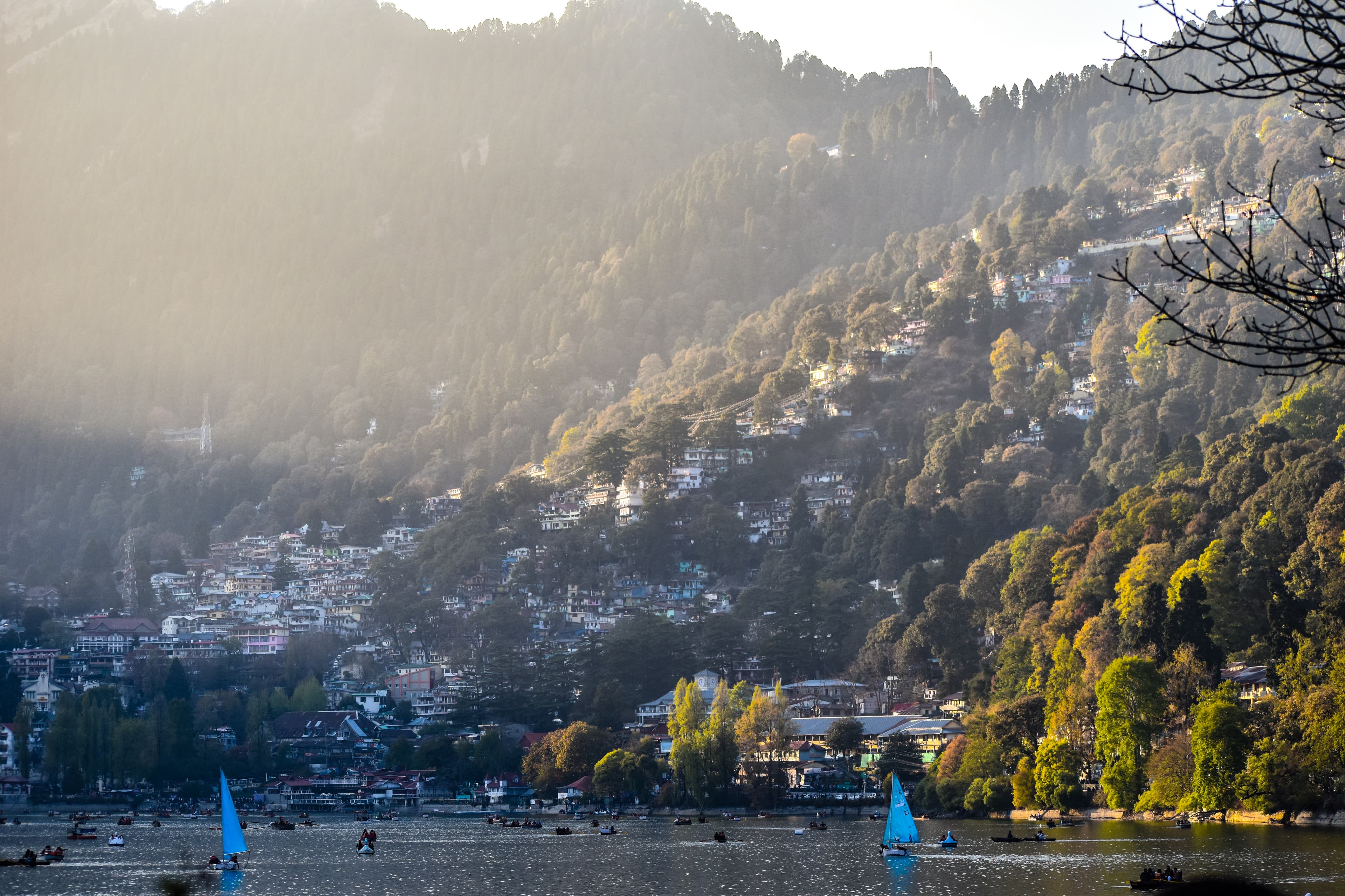 The Lake Naini surrounded by hills and lush greenery, with a reflection of the sky on the water